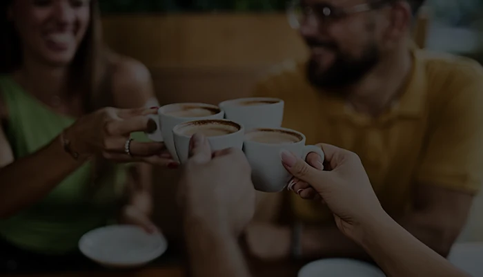 Amigos brindando com xícaras de café